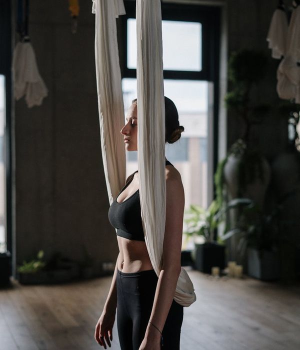 Woman in a peaceful yoga pose in a studio with soft lighting.